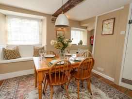 A dining room with a table set for meals at Little Wickers in Corfe Castle