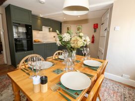 A dining room with a table set for a meal at Little Wickers in Corfe Castle