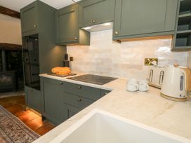 A kitchen with a cooktop and bread on a counter at Little Wickers in Corfe Castle
