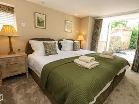 A bedroom with two beds and a bedside table at Little Wickers in Corfe Castle