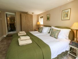 A bedroom with two beds and a wardrobe at Little Wickers in Corfe Castle