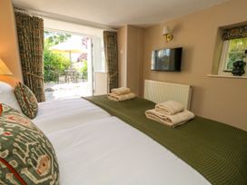 A bedroom with twin beds and a view to a garden at Little Wickers in Corfe Castle