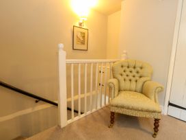 A hallway with a chair near the staircase at Little Wickers in Corfe Castle