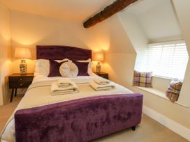 A bedroom with a bed and lamp at Little Wickers in Corfe Castle