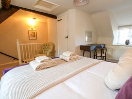 A bedroom with a bed and towels on top at Little Wickers in Corfe Castle