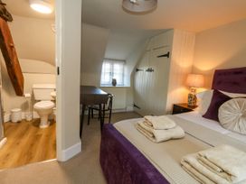 A bedroom with a bed and adjoining bathroom at Little Wickers Corfe Castle