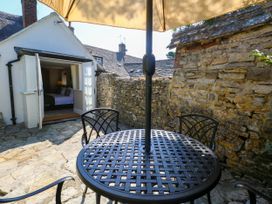 A table with chairs and an umbrella outside at Little Wickers Corfe Castle