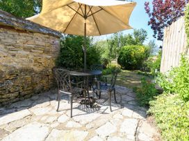 A garden with a table and chairs under an umbrella at Little Wickers Corfe Castle