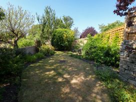 A garden with grass and trees at Little Wickers in Corfe Castle
