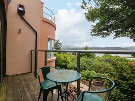 A balcony with a table and chairs overlooking a view at The Treehouse in Colwyn Bay