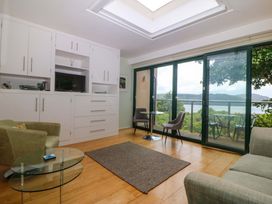 A living room with furniture and sliding glass doors at The Treehouse in Colwyn Bay