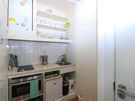 A kitchen with a sink, stove and storage at The Treehouse in Colwyn Bay
