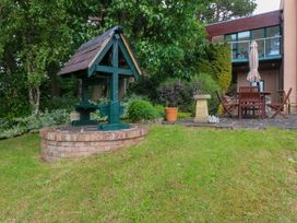 A garden with a well and furniture at The Treehouse in Colwyn Bay