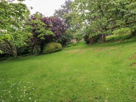 A garden with grass and trees at The Treehouse in Colwyn Bay