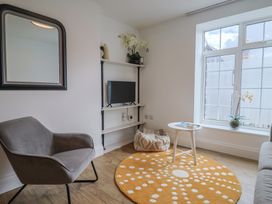 A living room with a mirror and television at Flat 1 Harley House in Sidmouth