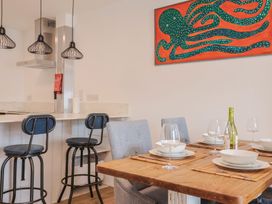 A dining room with a wooden table and kitchen counter at Flat 1 Harley House in Sidmouth