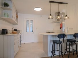 A kitchen with appliances and seating area at Flat 1 Harley House in Sidmouth