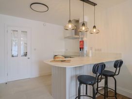 A kitchen with a bar area and stools at Flat 1 Harley House Sidmouth