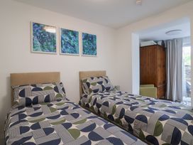 A bedroom with two beds and a wardrobe at Flat 1 Harley House in Sidmouth