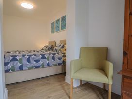 A bedroom with a bed and a chair at Flat 1 Harley House in Sidmouth