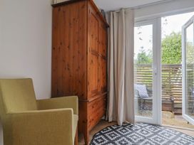 A seating area with an armchair and wardrobe at Flat 1 Harley House, Sidmouth