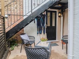 An outdoor patio with wetsuits hanging by the door at Flat 1 Harley House, Sidmouth