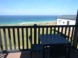 A table and chair on a deck overlooking the sea at 619 Chy-An-Mor Perranporth
