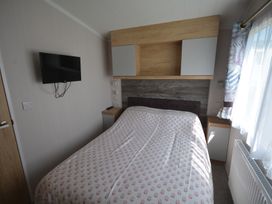 A bedroom with a bed and a wall-mounted television at 619 Chy-An-Mor in Perranporth