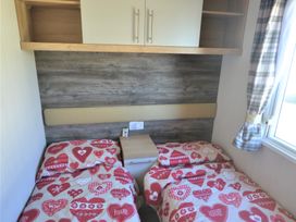 A bedroom with two beds and a nightstand at 619 Chy-An-Mor in Perranporth