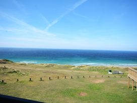 An outdoor scene with ocean and grassy hills at 619 Chy-An-Mor in Perranporth