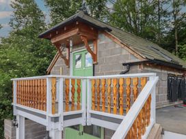 A balcony with a green door and slate roof at Hay Loft at Ebenezer Chapel Milwr