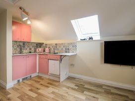 A kitchen with pink cabinets and patterned tiles at Hay Loft at Ebenezer Chapel in Milwr