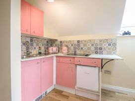 A kitchen with pink cabinets and appliances at Hay Loft at Ebenezer Chapel in Milwr