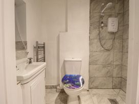 A bathroom with a sink, shower, toilet, and towel rail at Hay Loft at Ebenezer Chapel in Milwr