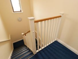 A staircase with a railing and window at Twyni Bach
