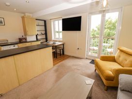 A living room with a kitchen bar and table at Twyni Bach
