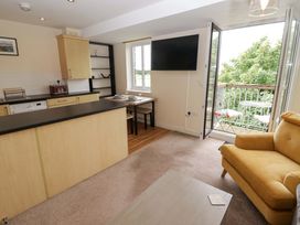 A living room with a sofa, table, and television at Twyni Bach in 