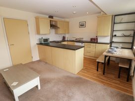 A kitchen with appliances and a dining table at Twyni Bach