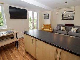 A living room with a television and dining table at Twyni Bach