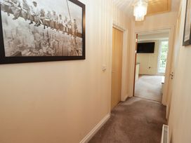 A hallway with a painting and light fixture at Twyni Bach