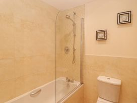 A bathroom with a bathtub and shower at Twyni Bach