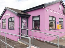 A cafe exterior with pink walls and signage at Crazie Crepes Cafe in 