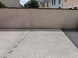 An outdoor paved area with a wall marked with numbers at Twyni Bach