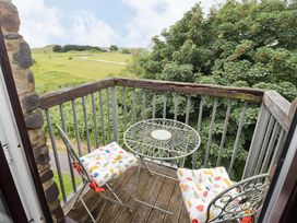 A balcony with a table and chairs at Twyni Bach in 
