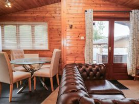 A dining area with a glass table and chairs at 89 Ambleside White Cross Bay