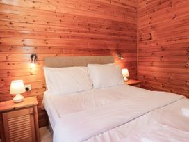 A bedroom with a bed and bedside tables at 89 Ambleside in White Cross Bay