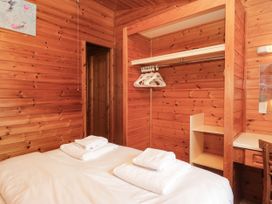 A bedroom with a bed and shelves at 89 Ambleside in White Cross Bay