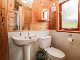 A bathroom with a sink, toilet, and window at 89 Ambleside in White Cross Bay