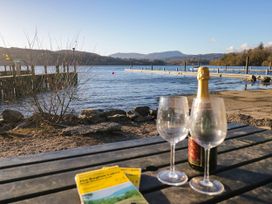 A table with glasses and a bottle near the lake at 89 Ambleside in White Cross Bay