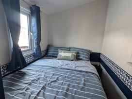 A bedroom with a bed and window at Presthaven - Denbigh Dunes, Gronant